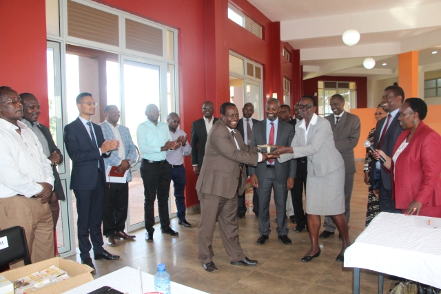 Prof. Rose Nyikal, Ag. Principal College of Agriculture and Veterinary Sciences presents keys of the WMI Campus to Prof. Henry Mutembei (left), Director, WMI during the handing over ceremony at the WMI campus. Witnessing the exercise is Prof. Stephen G. Kiama (background), Mr. Peter Wekesa, college registrar, contractors and representatives from the Green Belt Movement.